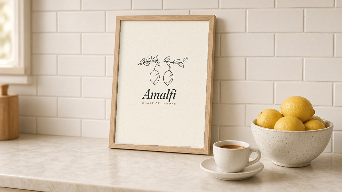 The Amalfi Art Print, framed on a kitchen counter next to a bowl of lemons and an espresso cup