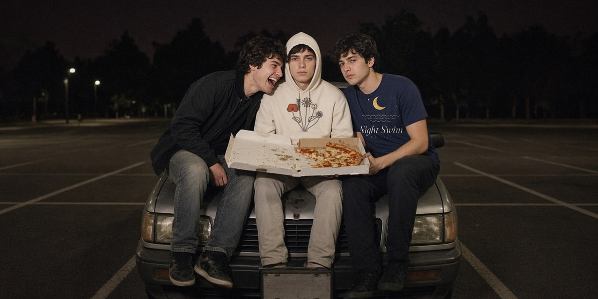 Three friends on a car hood in an empty lot at night, pizza box, on-camera flash - The Wildflower Season Hoodie & The Night Swim Society Tee - Good Vibes Bad Ideas