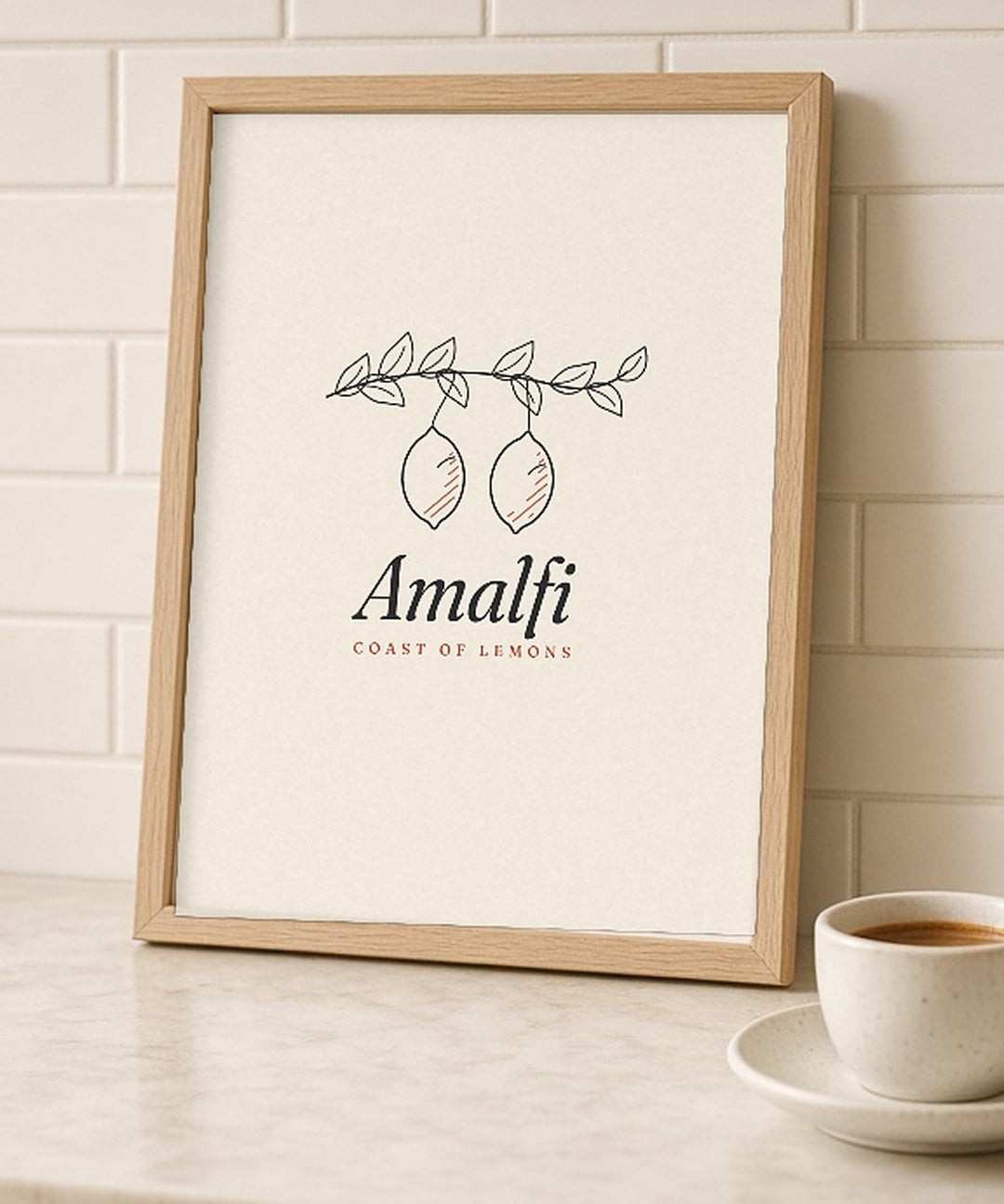 The Amalfi Art Print, framed on a kitchen counter next to a bowl of lemons and an espresso cup