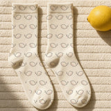 The Amalfi Socks in Cream, flat lay with a lemon, a paperback and sunglasses on a cream towel