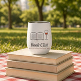 The Book Club Wine Tumbler on a stack of paperbacks on a gingham picnic blanket