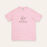 The Brunch Is My Cardio Tee in Blossom, flat lay front, product shot on cream