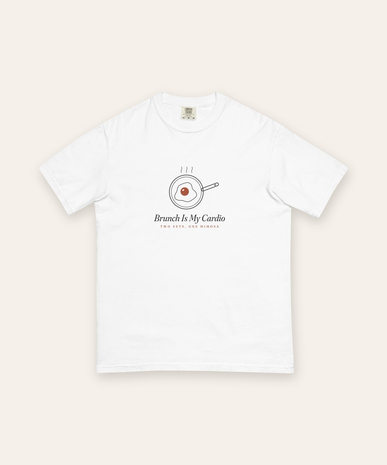 The Brunch Is My Cardio Tee in White, flat lay front, product shot on cream