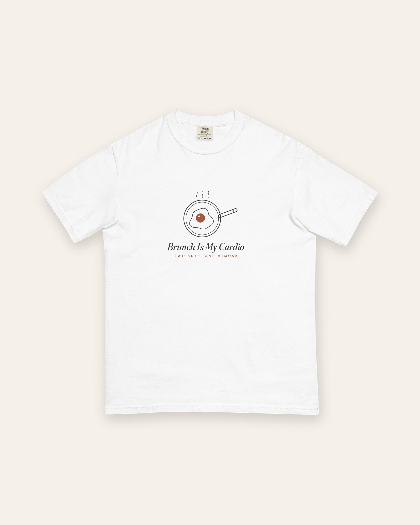 The Brunch Is My Cardio Tee in White, flat lay front, product shot on cream