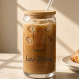 The Last Round Can Glass in Clear 16 oz, iced coffee with a bamboo lid and glass straw on a sunny counter
