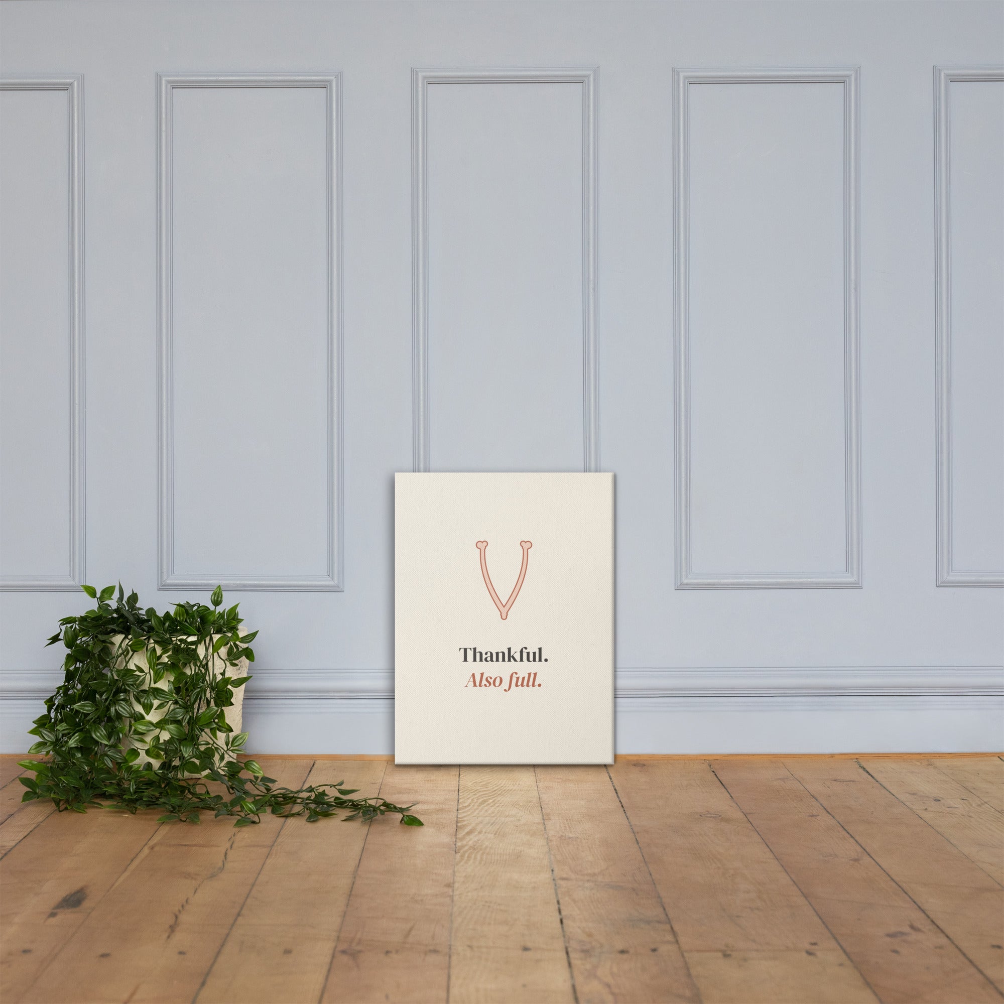 The canvas leaning against a paneled wall on a wooden floor
