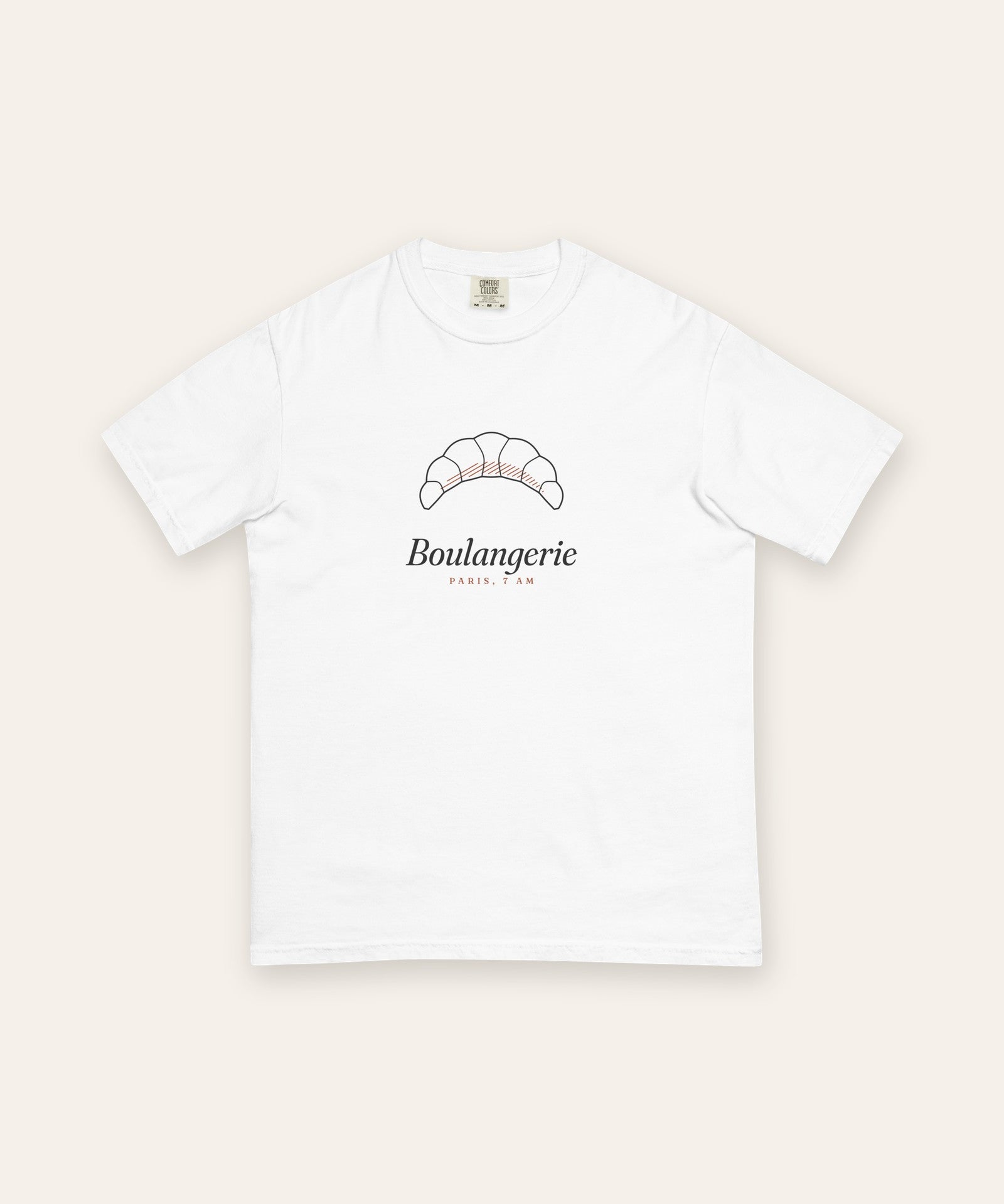 The Boulangerie Tee in White, flat lay front, product shot on cream