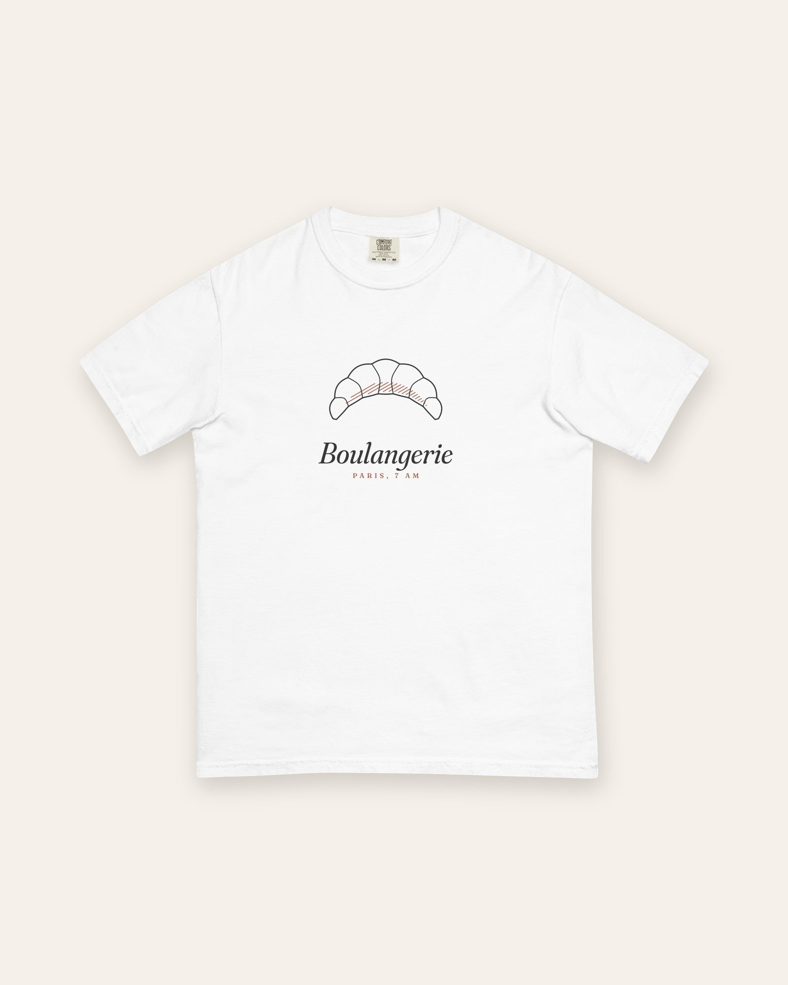 The Boulangerie Tee in White, flat lay front, product shot on cream