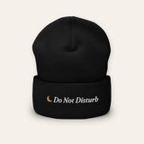The Do Not Disturb Beanie in Black, flat lay front, product shot on cream