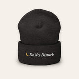 The Do Not Disturb Beanie in Dark Grey, flat lay front, product shot on cream