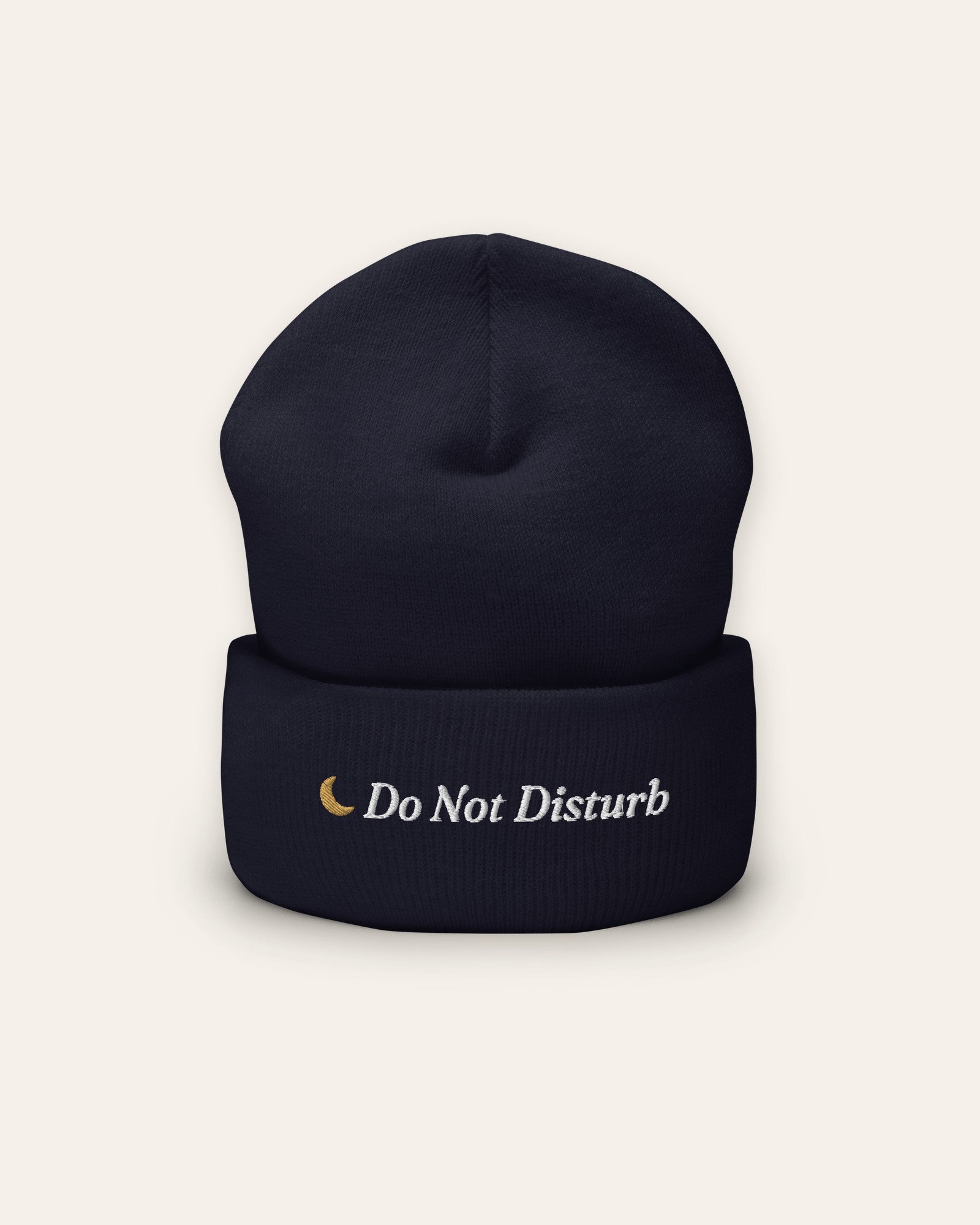 The Do Not Disturb Beanie in Navy, flat lay front, product shot on cream