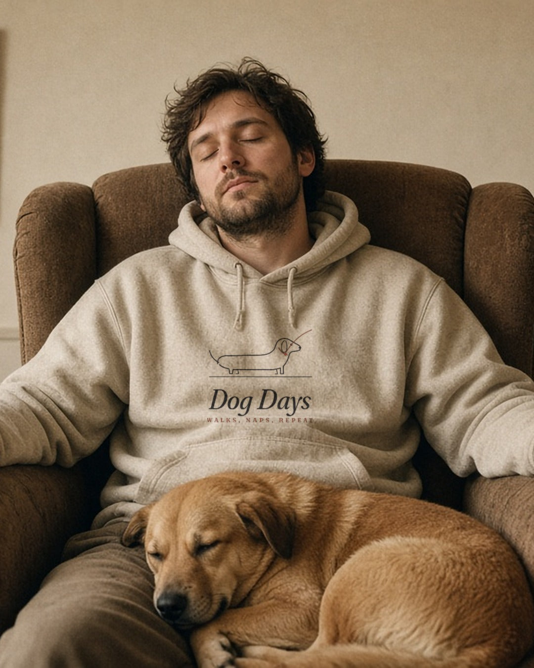 The Dog Days Hoodie in Oatmeal Heather, worn by a man asleep in an armchair with his dog on his lap