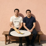 The Extra Virgin Tee in Ivory, worn by friends at a sidewalk café table with a baguette