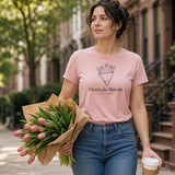 The Fleurs du Marché Tee in Blossom, a woman (30s) walks home with an armful of tulips far too big for her, coffee balanced on top, Blossom tee