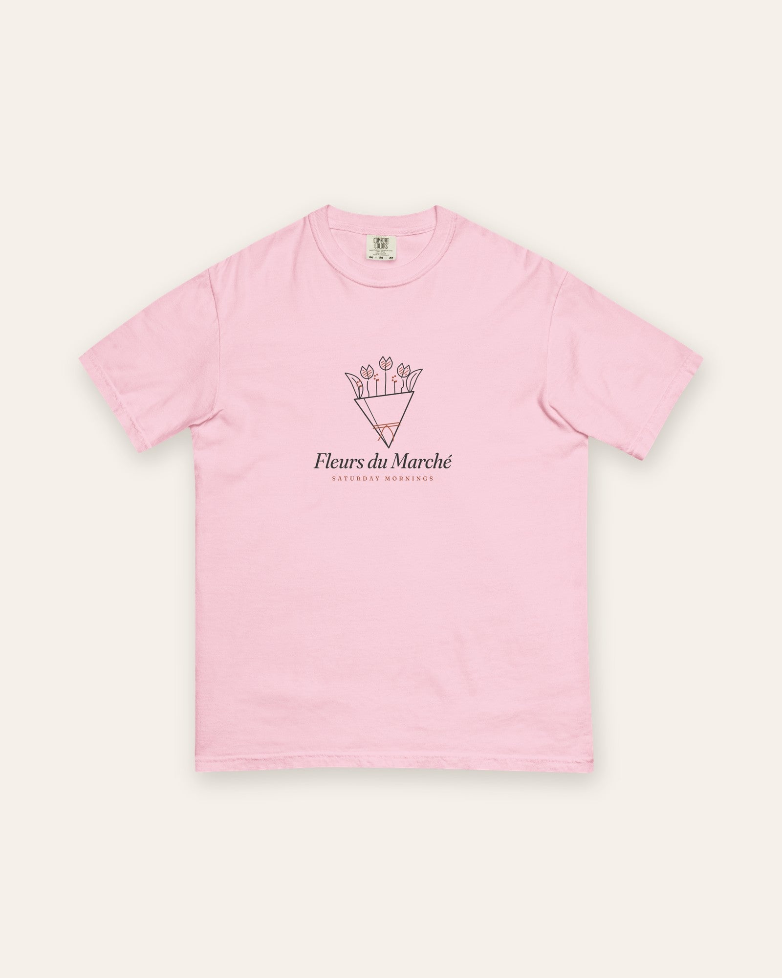 The Fleurs du Marché Tee in Blossom, flat lay front, product shot on cream