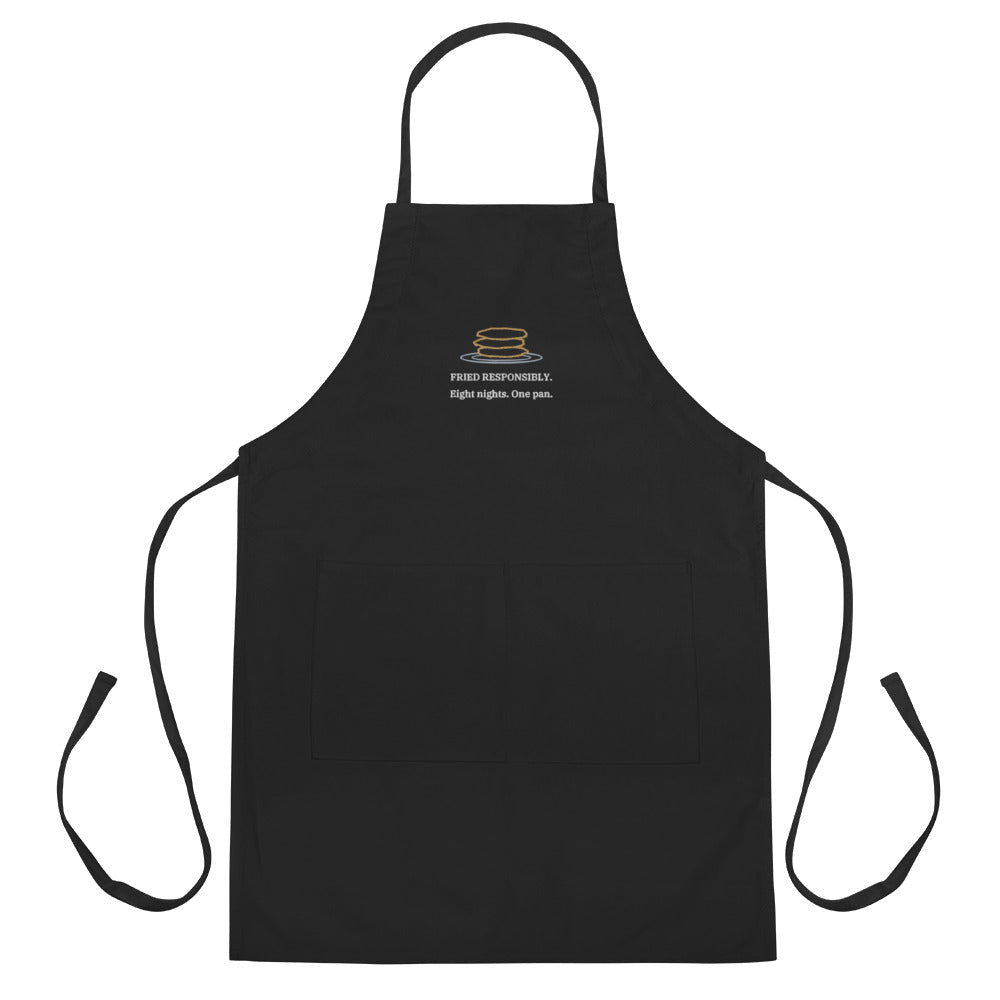 The Fried Responsibly Apron in black, embroidered latke stack and lettering, flat view