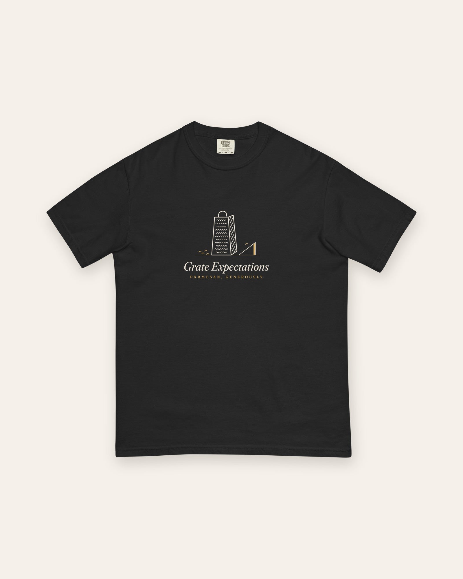 The Grate Expectations Tee in Black, flat lay front, product shot on cream