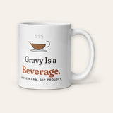 The Gravy Is a Beverage Mug, 11 oz, front, handle on right, product shot on cream