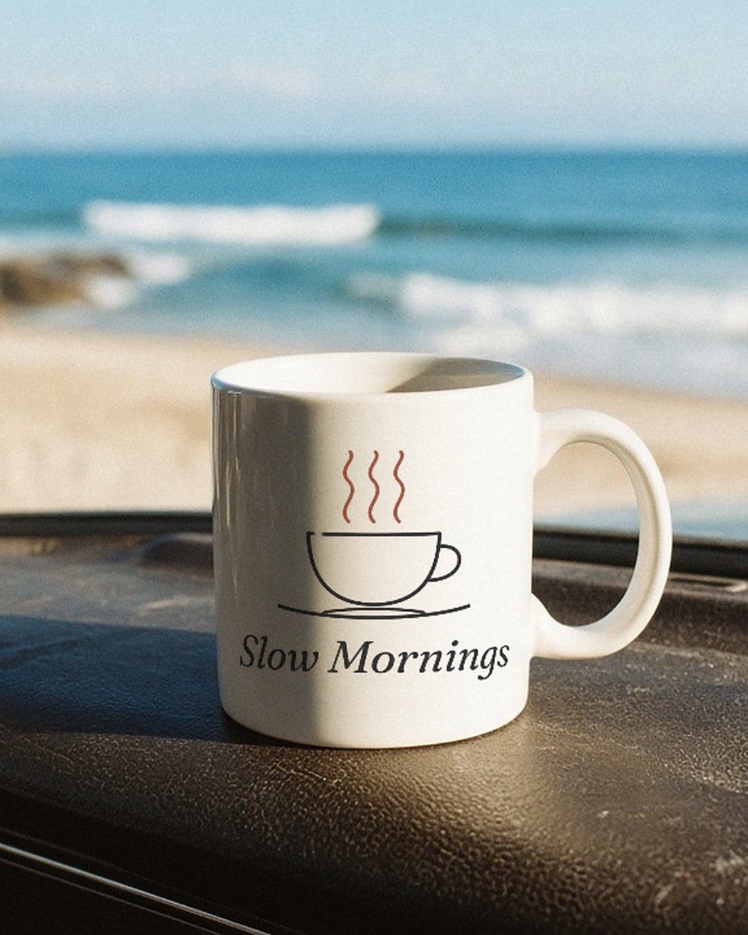 The Slow Mornings Mug on a van dashboard facing the surf