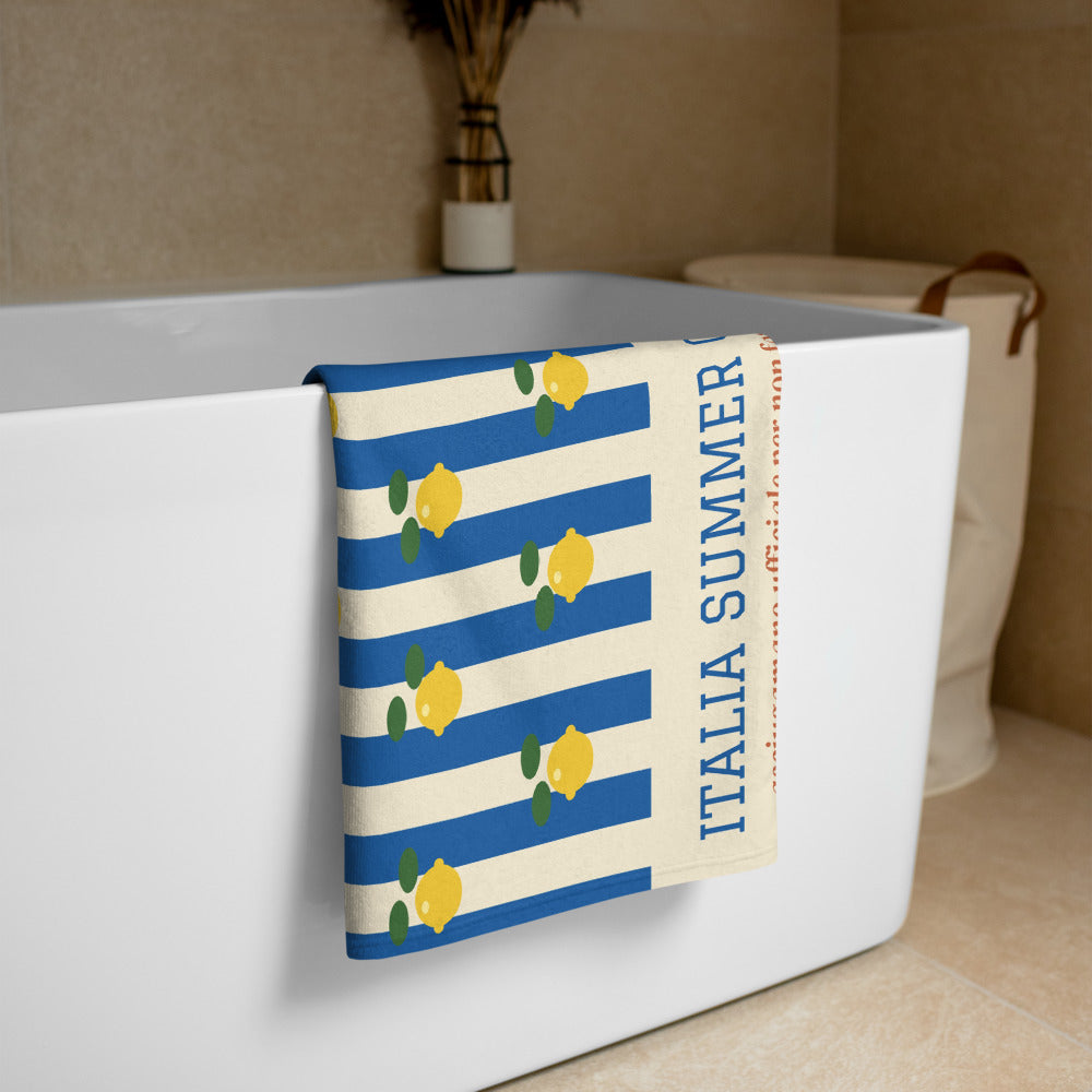 The Italia Summer Club Beach Towel, folded over a bathtub