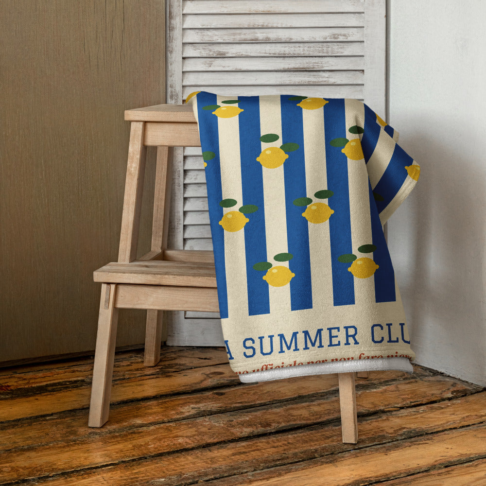 The Italia Summer Club Beach Towel, draped over a stool