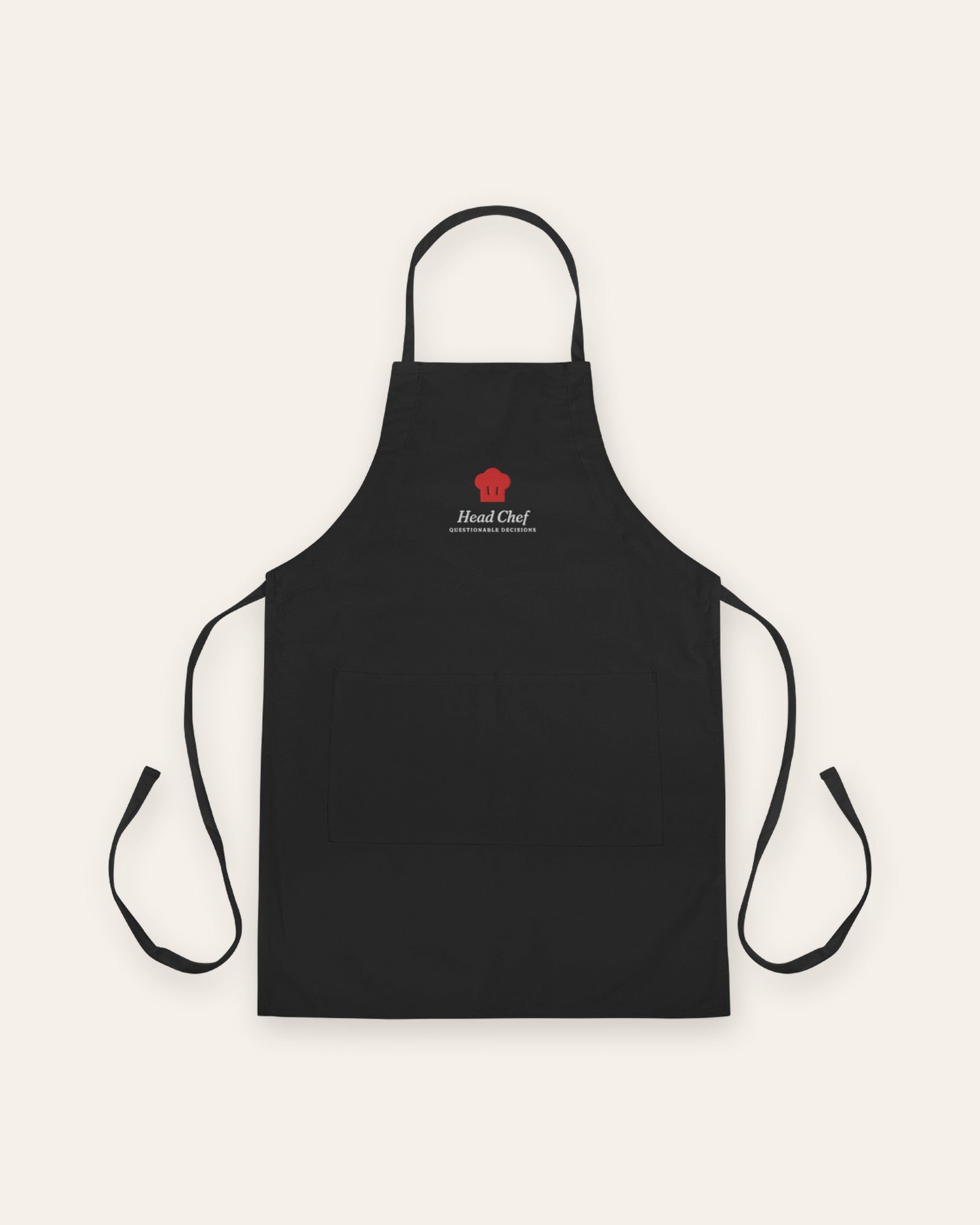 The Head Chef Apron in Black, flat lay front, product shot on cream