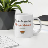 The Thanks for Hosting Mug on a desk next to a keyboard and a plant