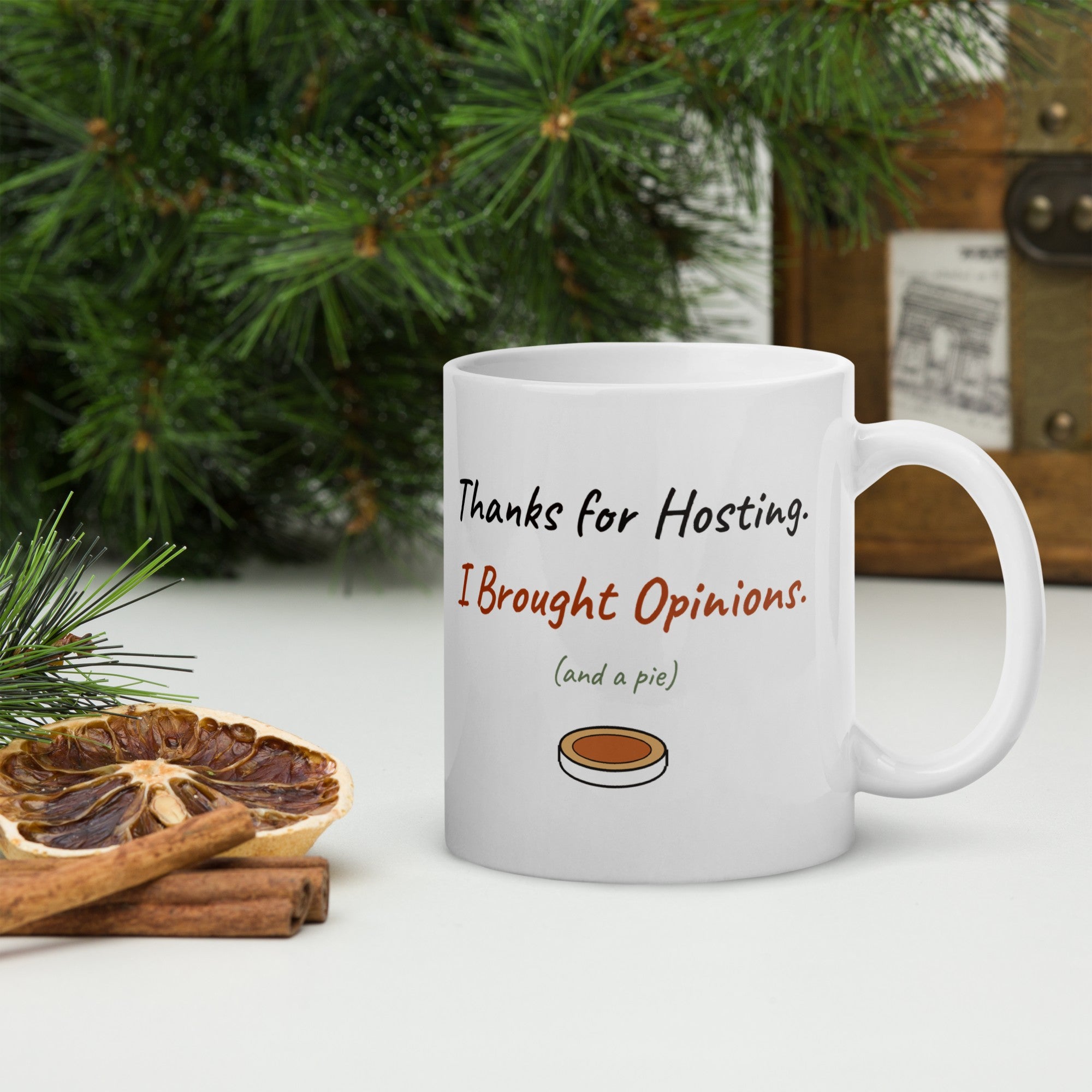 The Thanks for Hosting Mug on a table with pine branches and dried orange slices