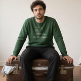 The Hot Mess Express Crewneck in Forest Green, a man sitting on an overstuffed suitcase to close it