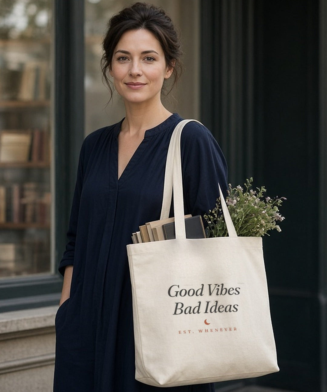 The House Tote in Oyster, oyster tote on a woman's shoulder outside a bookstore window, books and greens sticking out
