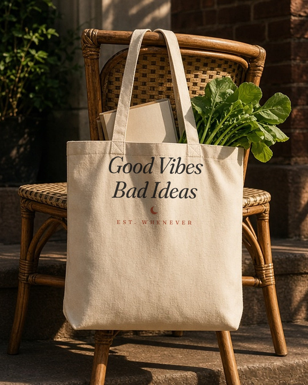 The House Tote in Oyster, tote on a wicker chair on a porch with fresh greens