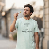 The Dirty Martini Tee in Chalky Mint, man holds a single olive up to the light like a jeweler, city street, open shade