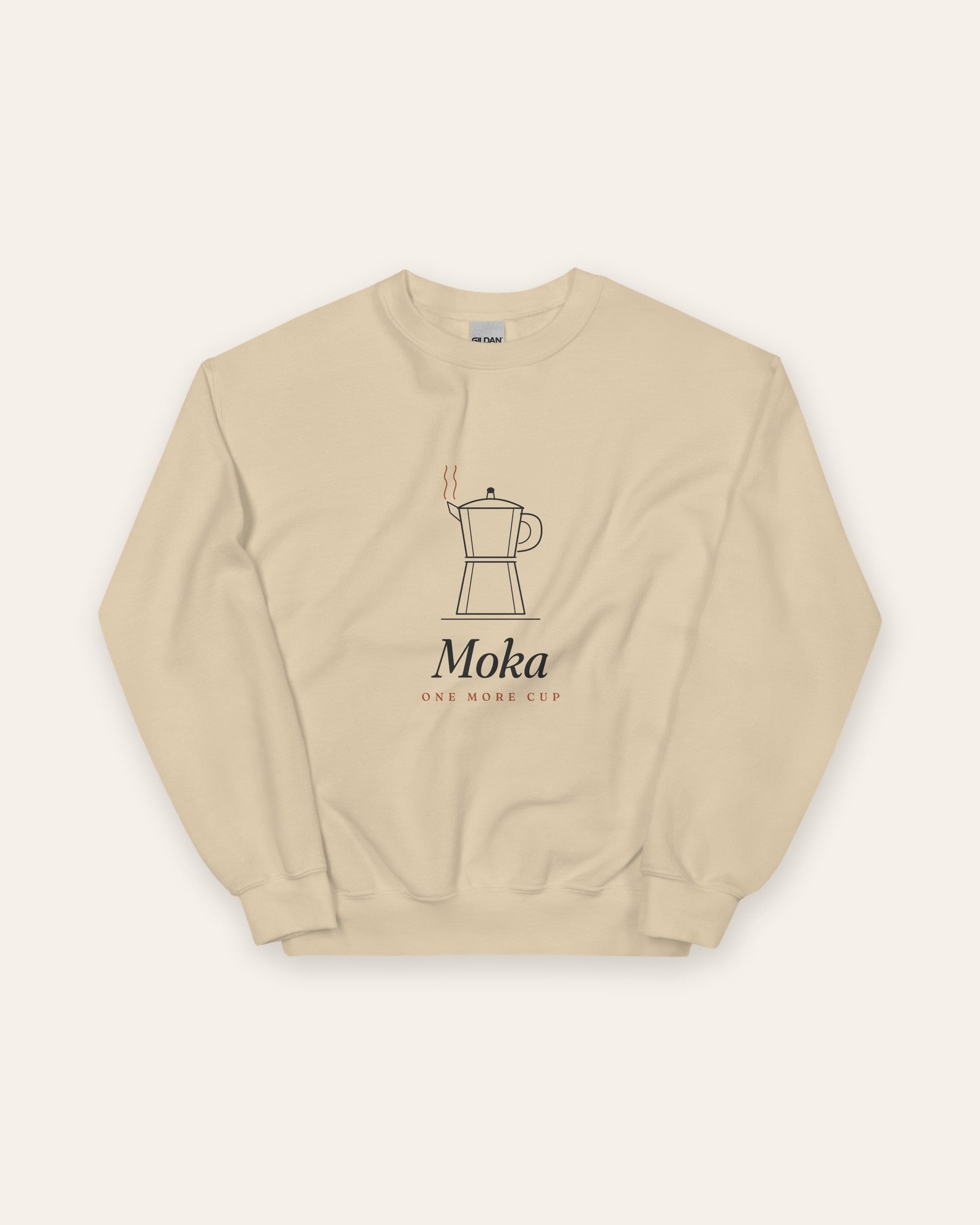 The Moka Crewneck in Sand, flat lay front, product shot on cream