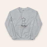 The Moka Crewneck in Sport Grey, flat lay front, product shot on cream