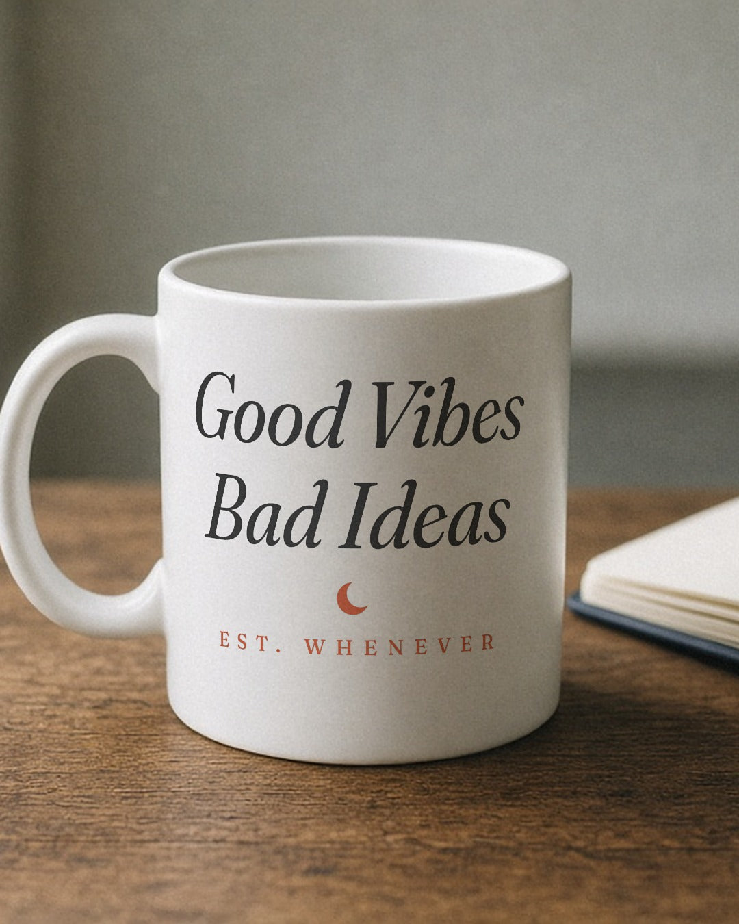 The House Mug in White 11 oz, mug (handle left, wordmark side to camera) beside an open notebook and a fountain pen