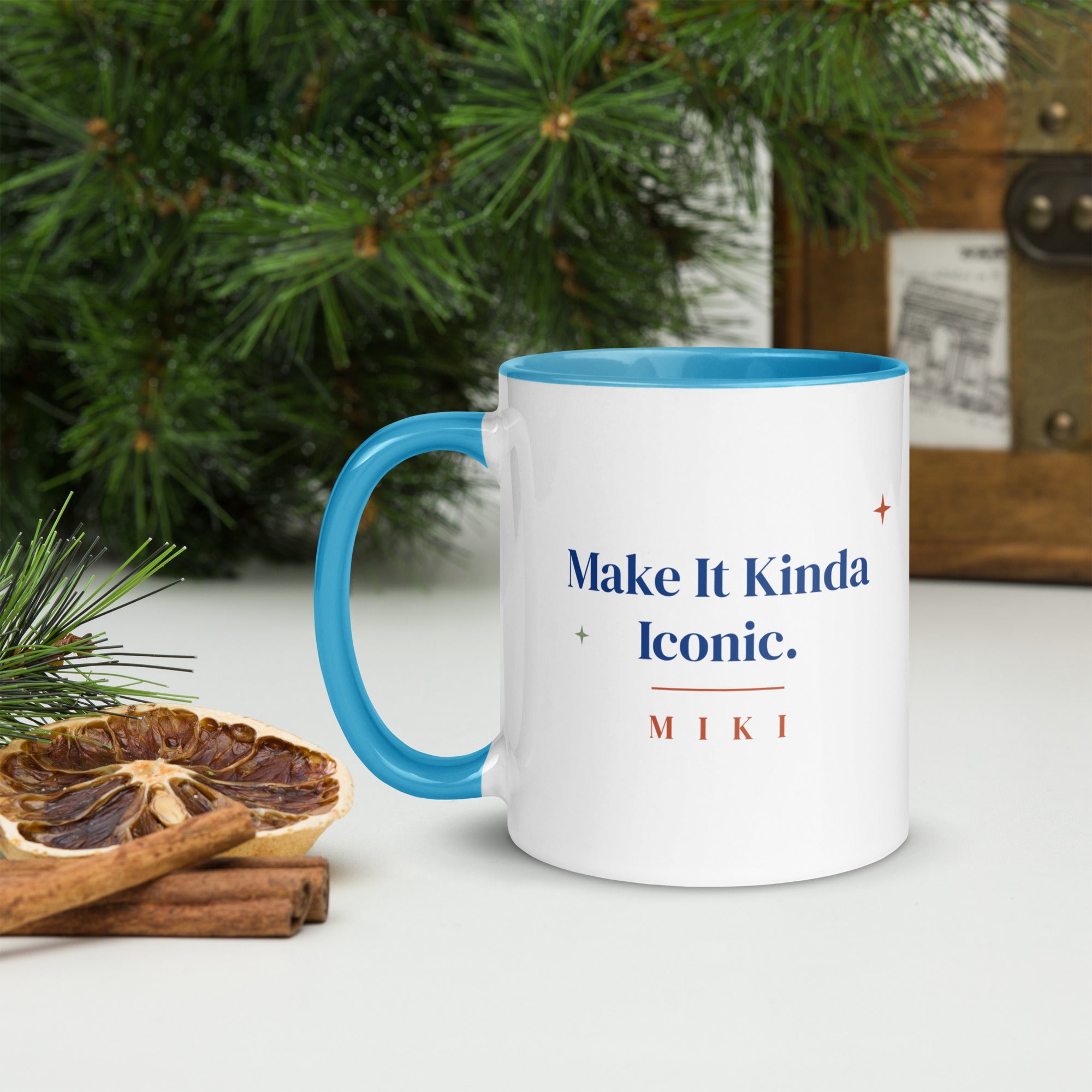 The mug next to pine branches and dried orange