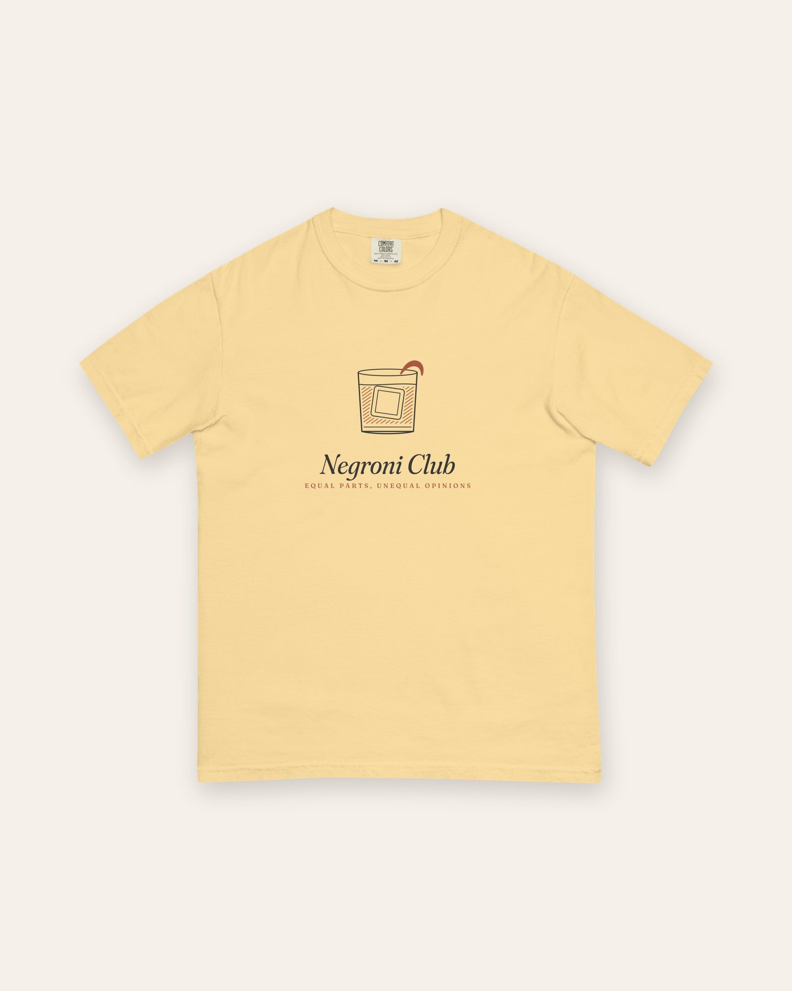 The Negroni Club Tee in Butter, flat lay front, product shot on cream