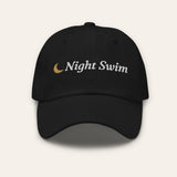 The Night Swim Dad Hat in Black, flat lay front, product shot on cream