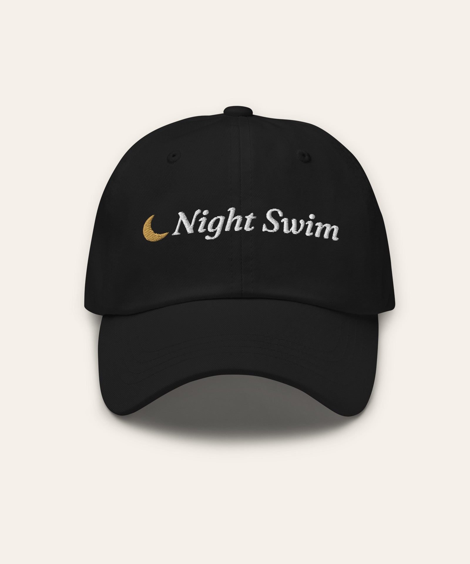 The Night Swim Dad Hat in Black, flat lay front, product shot on cream