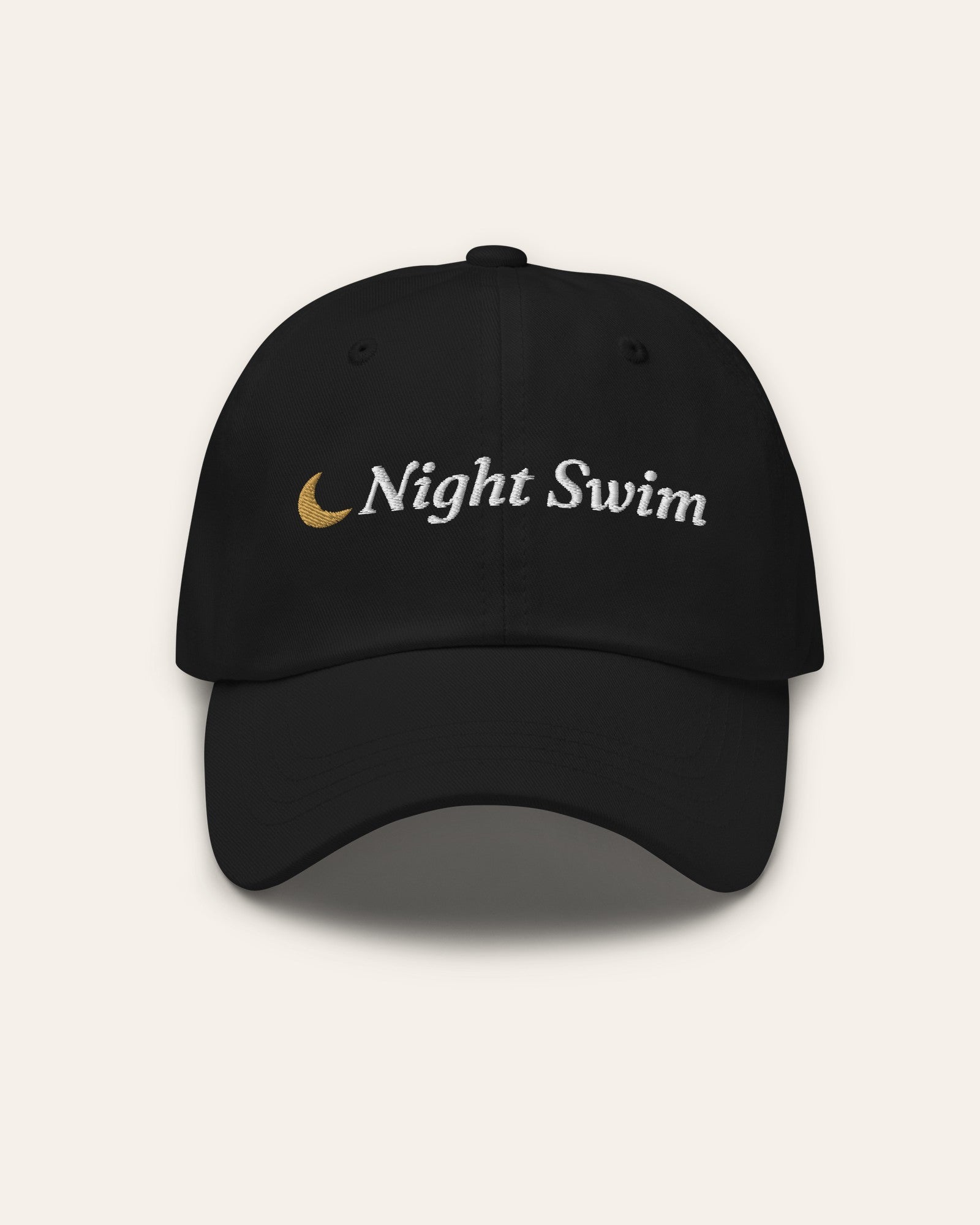 The Night Swim Dad Hat in Black, flat lay front, product shot on cream