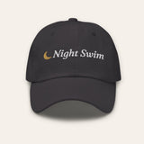 The Night Swim Dad Hat in Dark Grey, flat lay front, product shot on cream