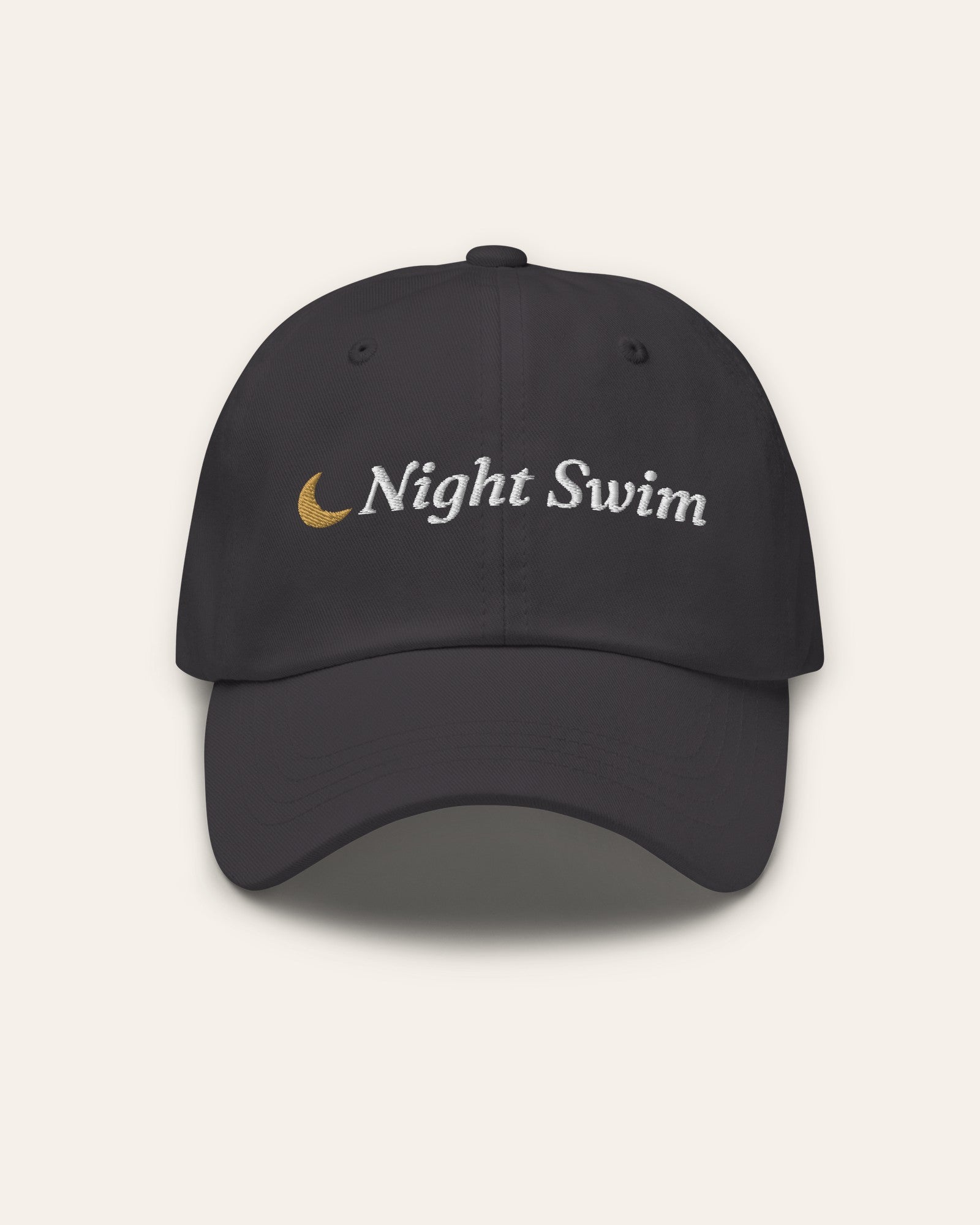 The Night Swim Dad Hat in Dark Grey, flat lay front, product shot on cream