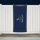 The Night Swim Beach Towel clipped to a white fence beside a motel pool at night
