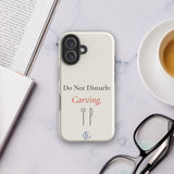 The Do Not Disturb Carving Phone Case on a desk with coffee
