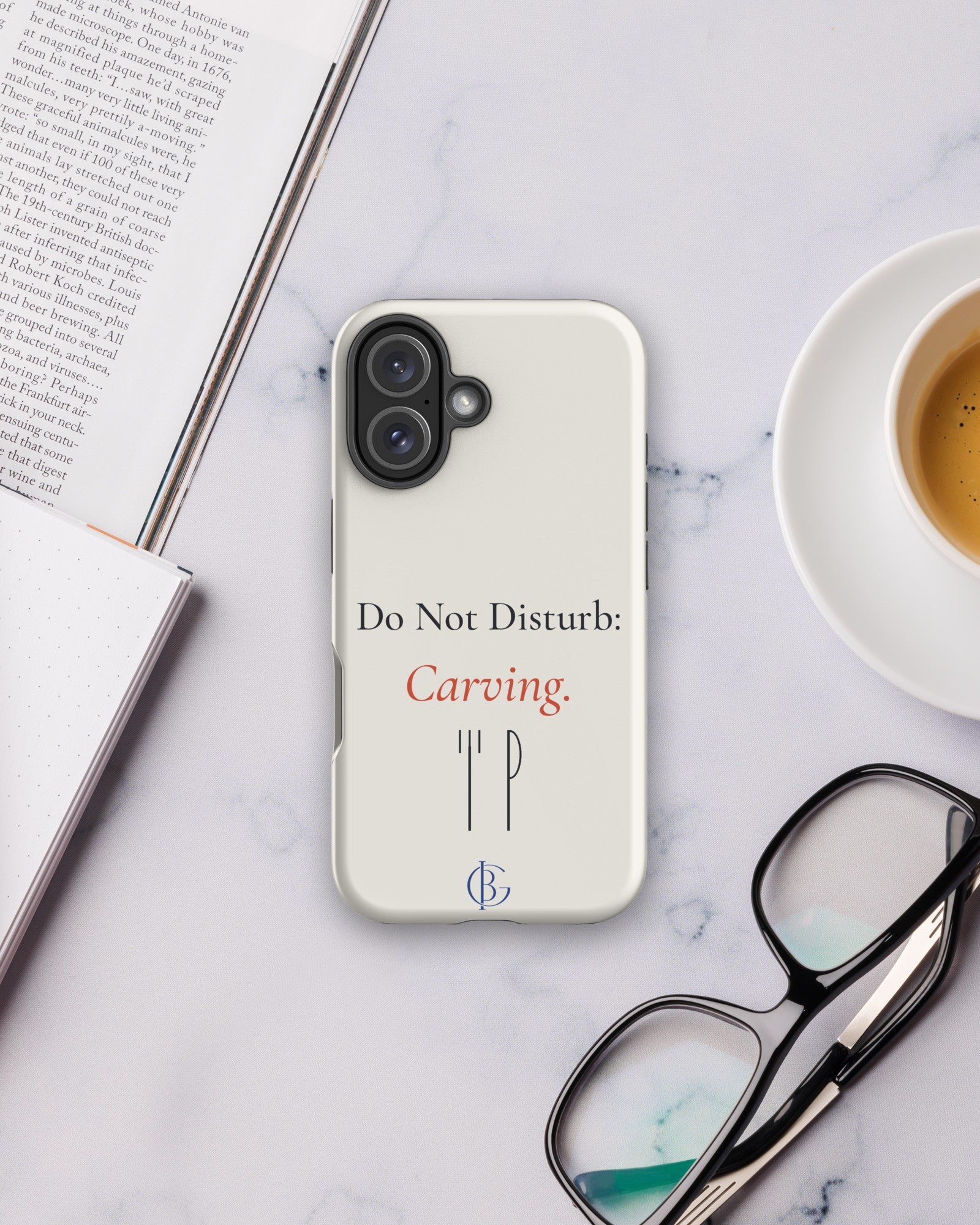 The Do Not Disturb Carving Phone Case on a desk with coffee