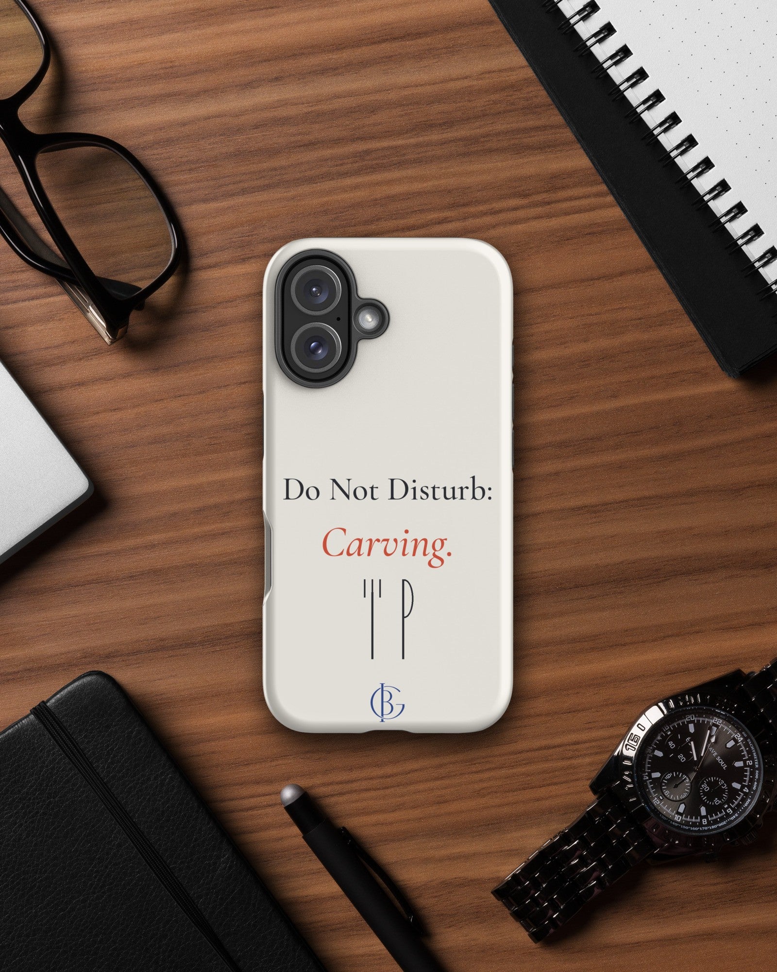 The Do Not Disturb Carving Phone Case on a wooden desk