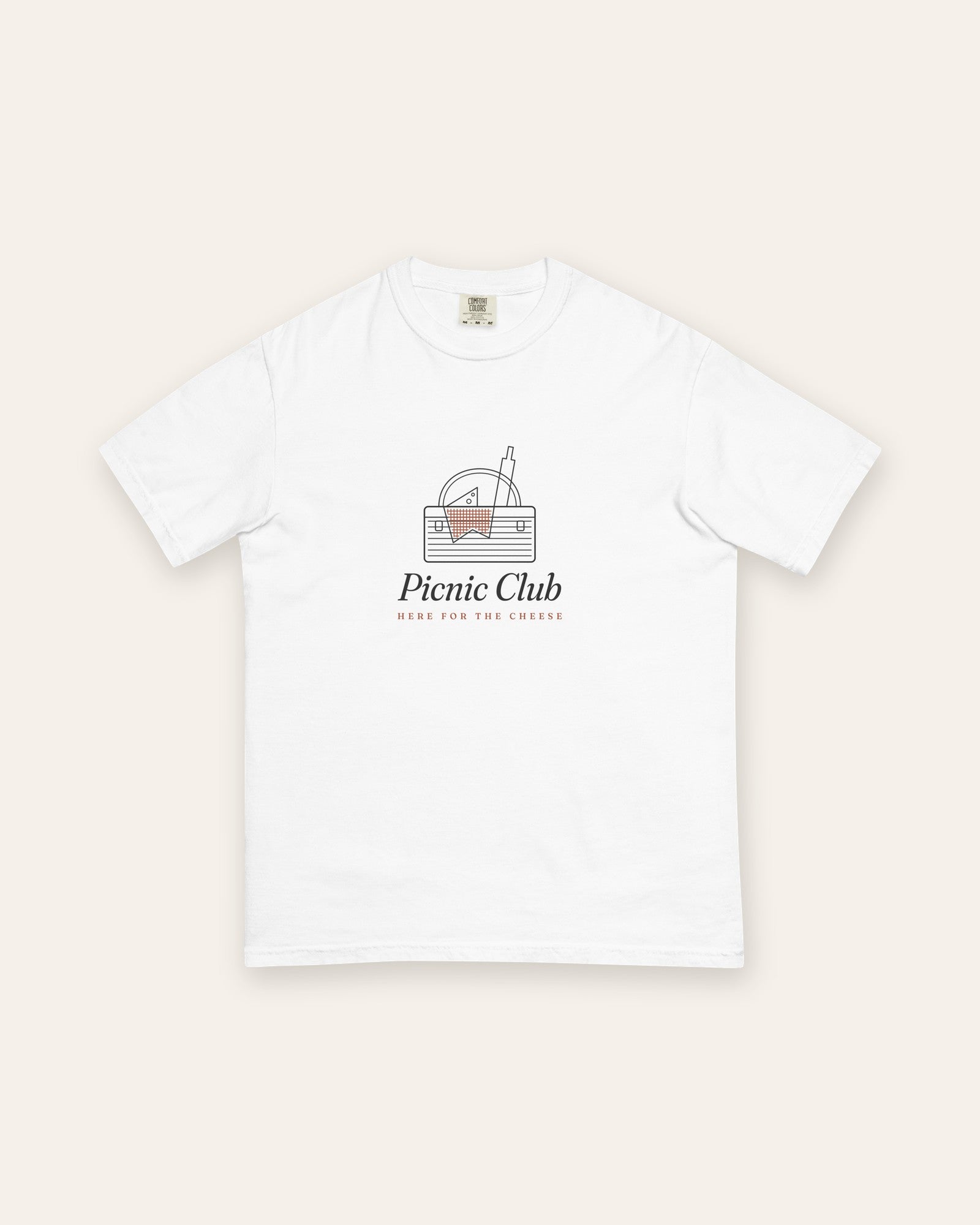 The Picnic Club Tee in White, flat lay front, product shot on cream