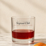 The Negroni Club Rocks Glass in Clear 10.5 oz, Negroni on a marble counter with a twist of orange peel