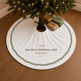 The tree skirt under a lit Christmas tree with wrapped gifts on a warm oak floor