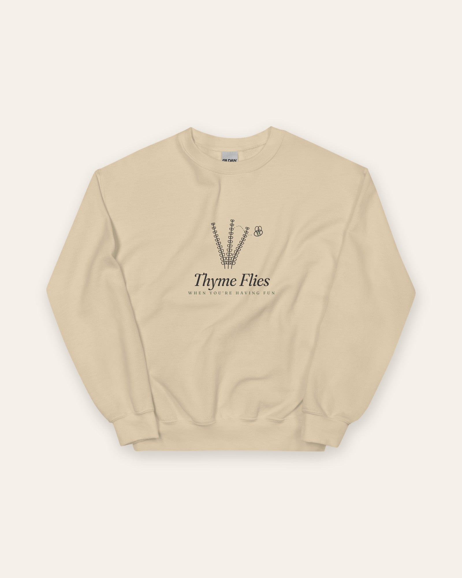The Thyme Flies Crewneck in Sand, flat lay front, product shot on cream